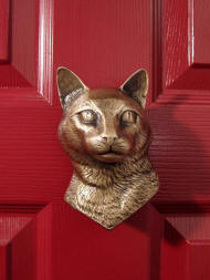 Cat door knocker on red door
